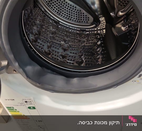 תוף מכונת כביסה פתוח עם תווית אנרגיה